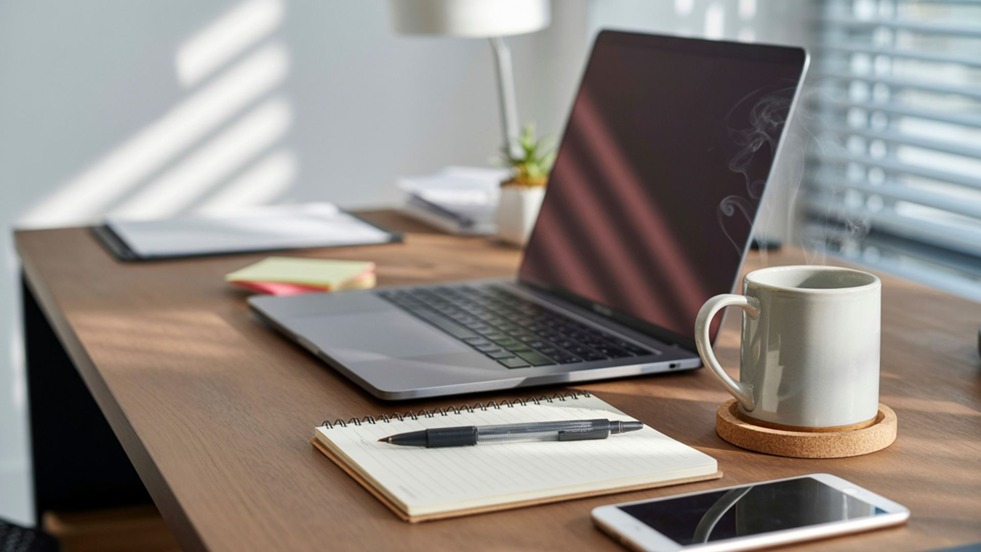 Et ryddig skrivebord i tre med en åpen bærbar datamaskin